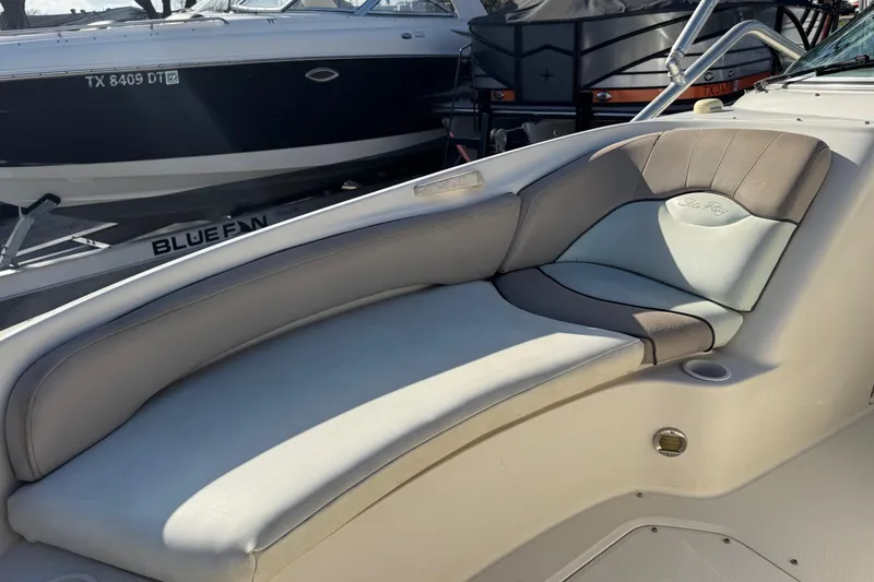 Slide: The Image of 2004 Sea Ray 240 Sundeck interior seating with cushioned lounge area. - 22