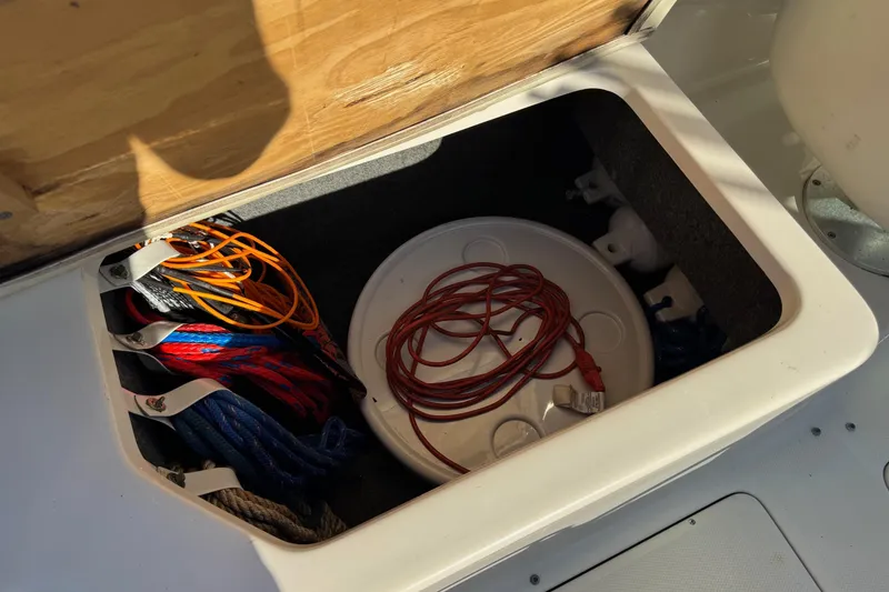 Slide: The Image of Storage compartment on a 2004 Sea Ray 240 Sundeck with ropes and accessories. - 28