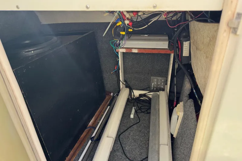 Slide: The Image of Interior view of a 2004 Sea Ray 240 Sundeck storage compartment with wiring and equipment. - 36