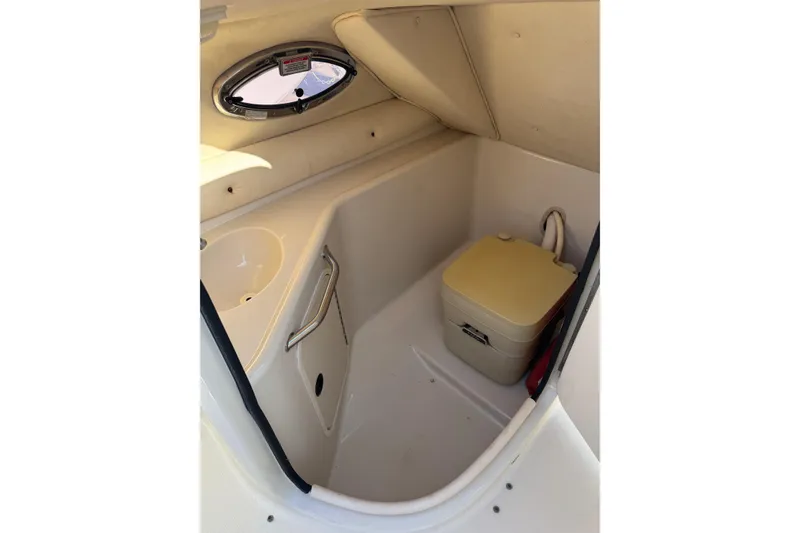 Slide: The Image of 2004 Sea Ray 240 Sundeck interior with portable toilet and sink. - 37