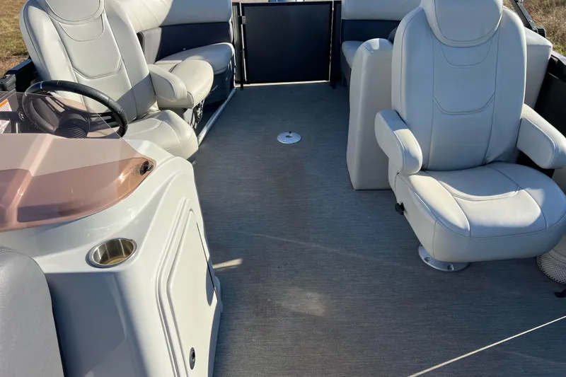 Slide: The Image of 2022 Sylvan Mirage X1 Tritoon interior with plush seating and steering console. - 21