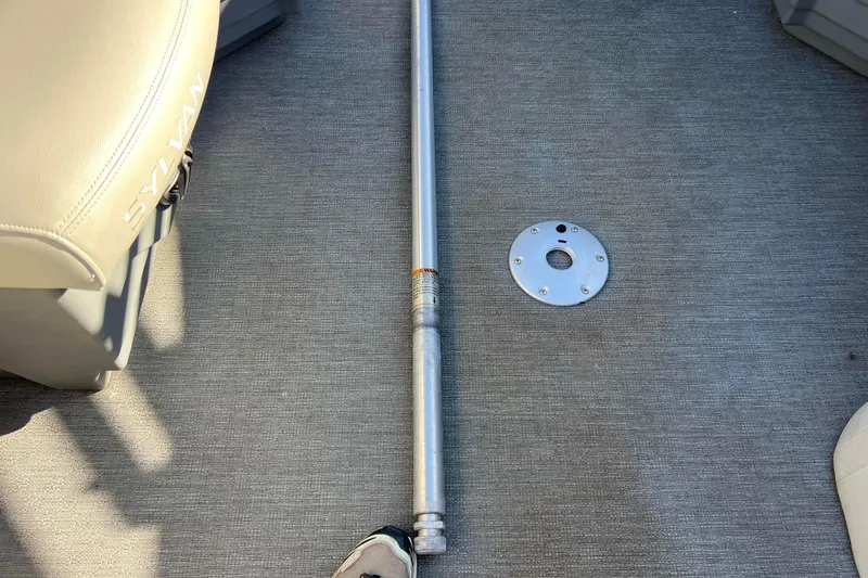 Slide: The Image of Interior of 2022 Sylvan Mirage X1 Tritoon with seat and metal pole on carpeted floor. - 26