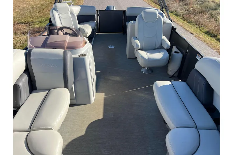 Slide: The Image of 2022 Sylvan Mirage X1 Tritoon interior with plush seating and modern helm. - 3
