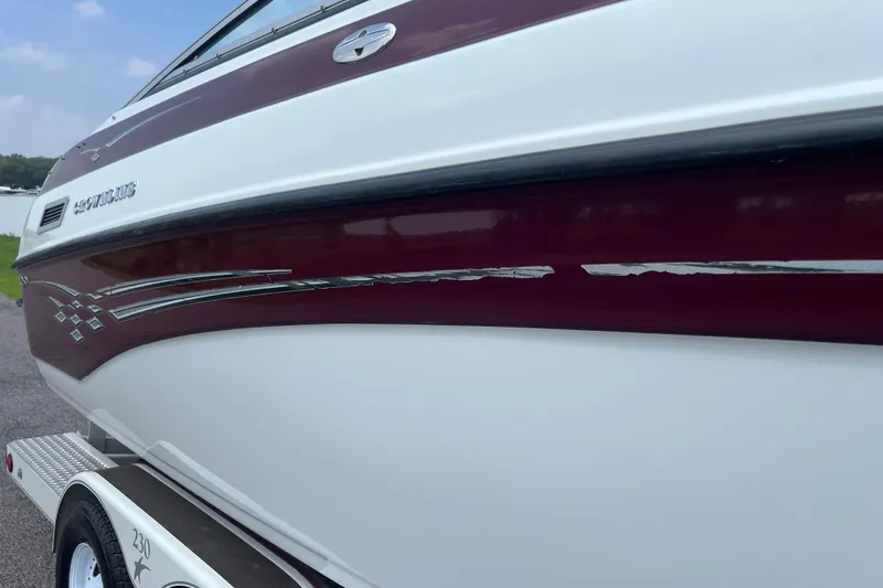 Slide: The Image of 2003 Crownline 230 BR boat with maroon and white exterior detailing. - 11