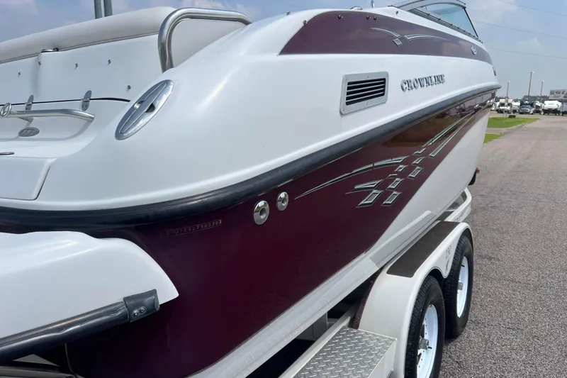 Slide: The Image of 2003 Crownline 230 BR boat on trailer, featuring sleek maroon and white design. - 15