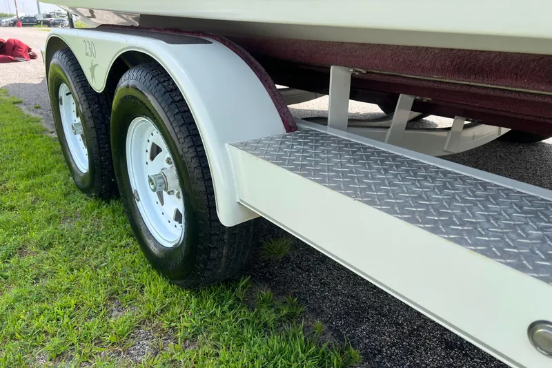 Slide: The Image of Trailer of 2003 Crownline 230 BR boat with dual wheels on grass. - 21