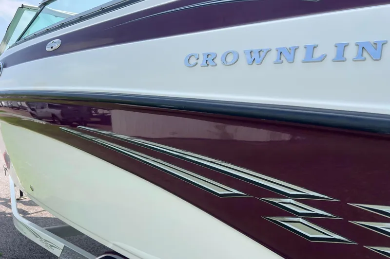 Slide: The Image of 2003 Crownline 230 BR boat with maroon and white exterior detailing. - 22