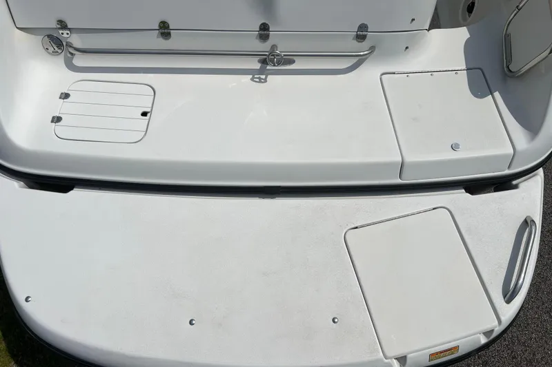 Slide: The Image of 2003 Crownline 230 BR boat deck with storage compartments and clean white surface. - 31