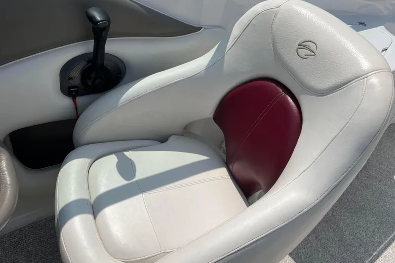 Slide: The Image of 2003 Crownline 230 BR boat seat with white and maroon upholstery, featuring a control lever. - 37
