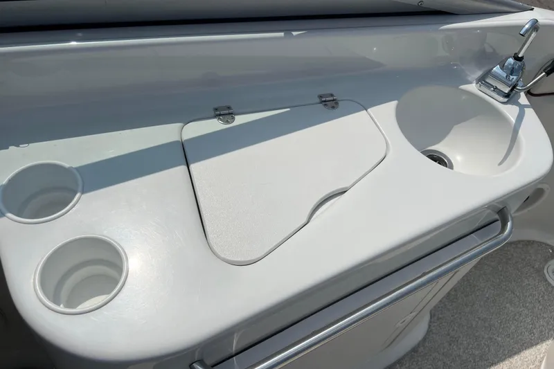 Slide: The Image of 2003 Crownline 230 BR boat interior with sink, faucet, and cup holders. - 42
