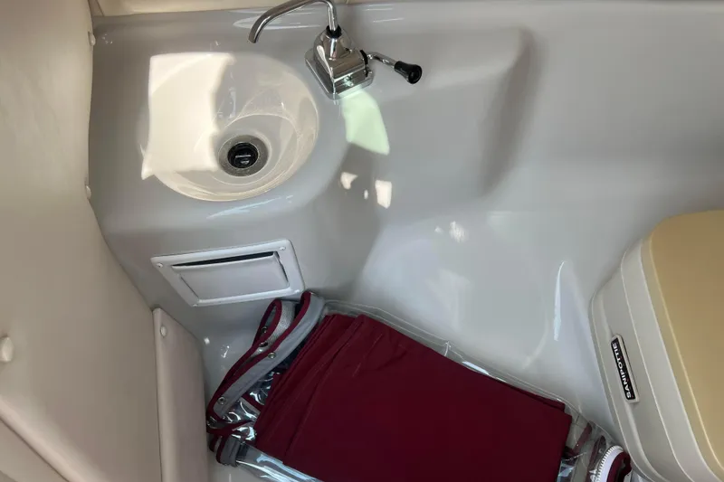 Slide: The Image of 2003 Crownline 230 BR boat interior with sink and storage area. - 46