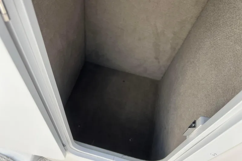 Slide: The Image of Storage compartment inside a 2003 Crownline 230 BR boat, featuring carpeted interior. - 48