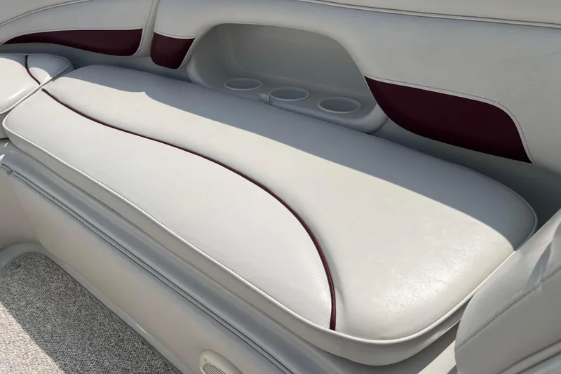 Slide: The Image of 2003 Crownline 230 BR boat interior with white and maroon seating and cup holders. - 49