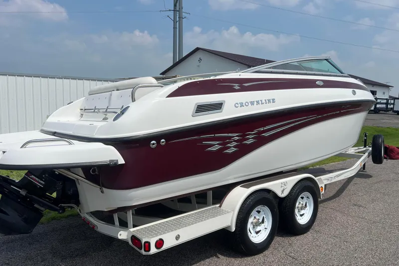 Slide: The Image of 2003 Crownline 230 BR boat on trailer, maroon and white design, parked outdoors. - 5