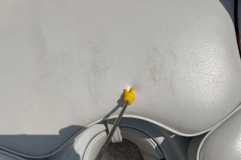 Slide: The Image of Yellow tool on white leather seat of 2003 Crownline 230 BR boat. - 52