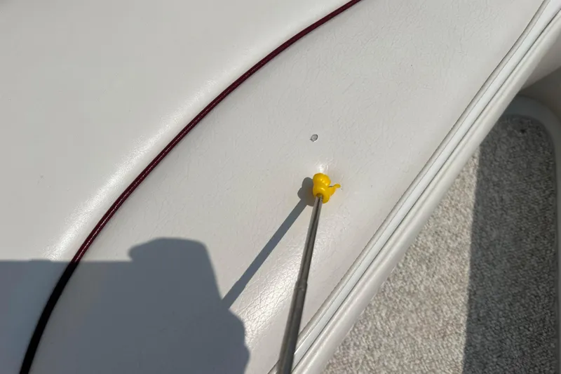 Slide: The Image of Yellow tool on white upholstery of 2003 Crownline 230 BR boat. - 53