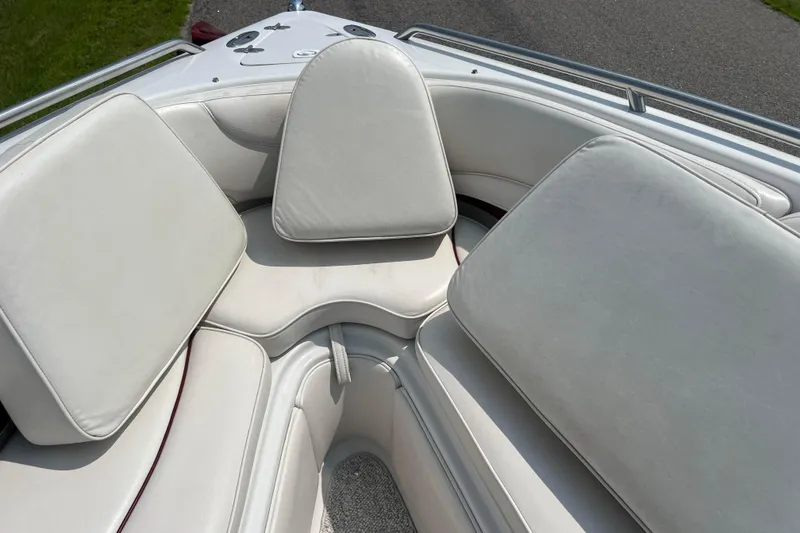 Slide: The Image of 2003 Crownline 230 BR boat interior with white cushioned seating. - 54