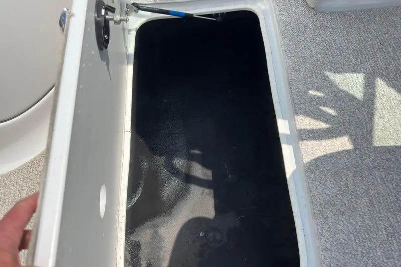 Slide: The Image of Open storage compartment in 2003 Crownline 230 BR boat, showing interior details. - 56