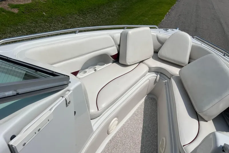 Slide: The Image of 2003 Crownline 230 BR boat interior with white cushioned seating and cup holders. - 57