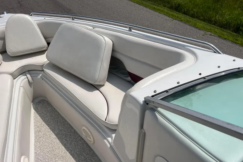 Slide: The Image of 2003 Crownline 230 BR boat interior with white cushioned seating and carpeted floor. - 58