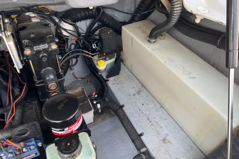 Slide: The Image of Engine compartment of a 2003 Crownline 230 BR boat, showing mechanical components and wiring. - 64