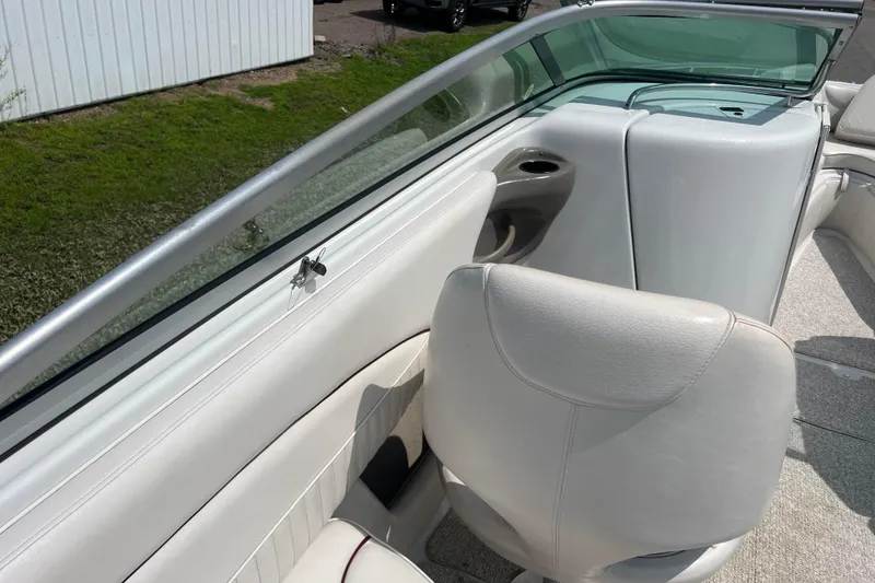 Slide: The Image of 2003 Crownline 230 BR boat interior with white seating and cup holder. - 65