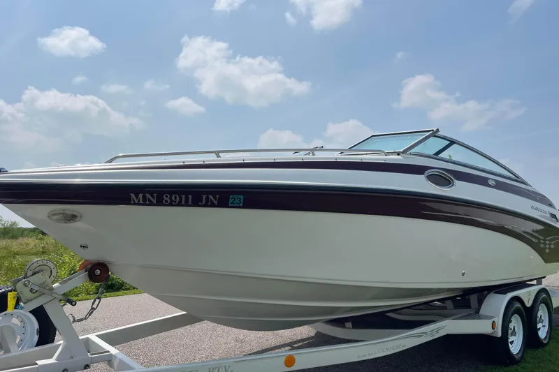 Slide: The Image of 2003 Crownline 230 BR boat on trailer under a clear sky. - 8