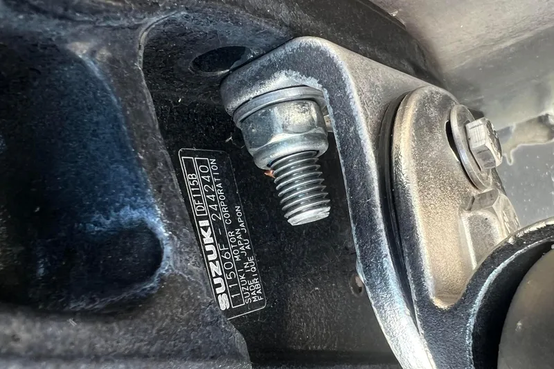 Slide: The Image of Close-up of a Suzuki engine component with visible bolts and identification plate. Viaggio Diamante Q 2022. - 11
