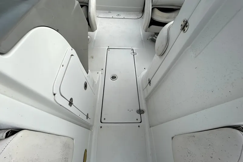 Slide: The Image of 2005 Crownline 220 LS boat interior with white seating and storage compartments. - 18