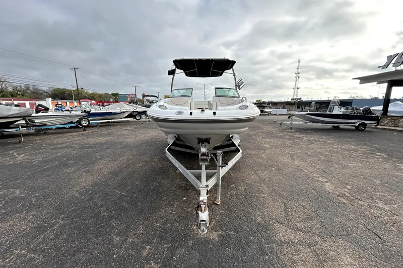 Slide: The Image of 2005 Crownline 220 LS boat on trailer in outdoor lot under cloudy sky. - 2
