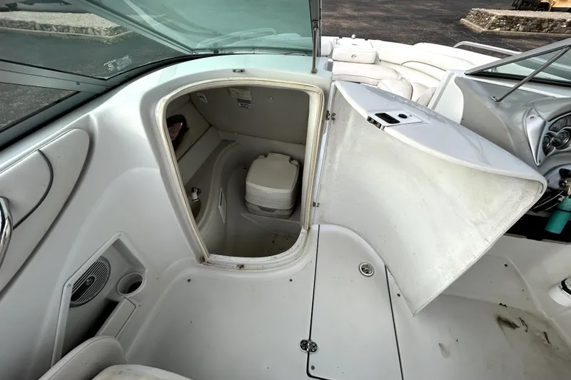 Slide: The Image of 2005 Crownline 220 LS boat interior with open storage compartment and seating area. - 21