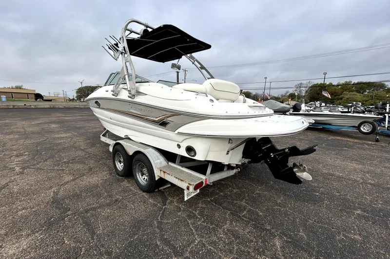 Slide: The Image of 2005 Crownline 220 LS boat on trailer, parked outdoors under cloudy sky. - 5
