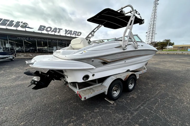 Slide: The Image of 2005 Crownline 220 LS boat on trailer at dealership, showcasing sleek design and features. - 7