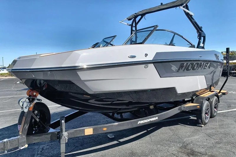The Image of 2026 Moomba Max boat on trailer in parking lot, clear sky background. - 1