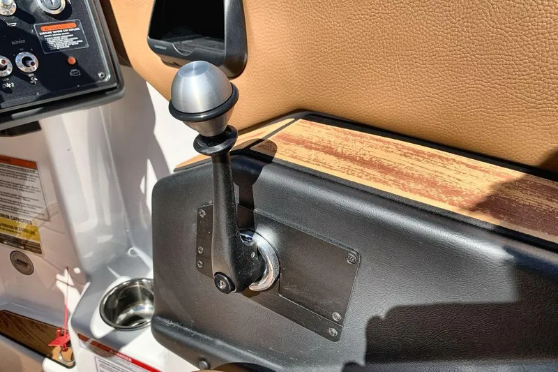 Slide: The Image of 2026 Moomba Max boat throttle lever and control panel, featuring wood and leather accents. - 16