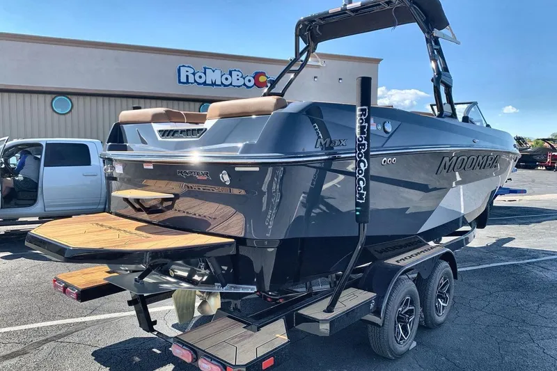 Slide: The Image of 2026 Moomba Max boat on trailer in parking lot, showcasing sleek design and modern features. - 5