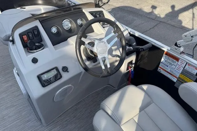 Slide: The Image of 2022 Bennington S 18 Fishing boat dashboard with steering wheel and controls. - 12