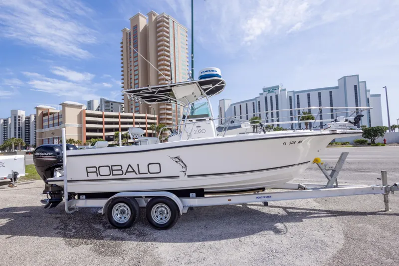 The Image of 1997 Robalo R230 Center Console boat on trailer, urban background, clear sky. - 0