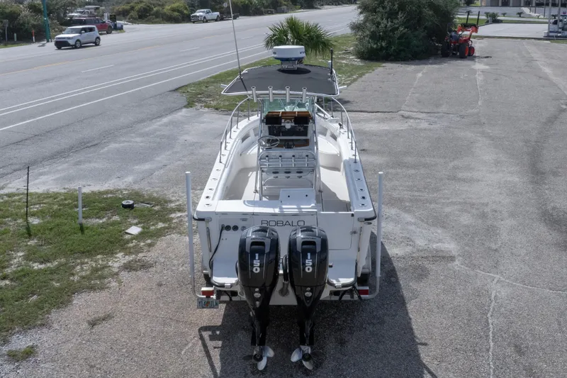 Slide: The Image of 1997 Robalo R230 Center Console boat with dual 150 horsepower engines, parked near a road. - 13
