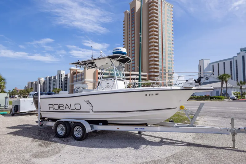 Slide: The Image of 1997 Robalo R230 Center Console boat on trailer, cityscape background. - 16