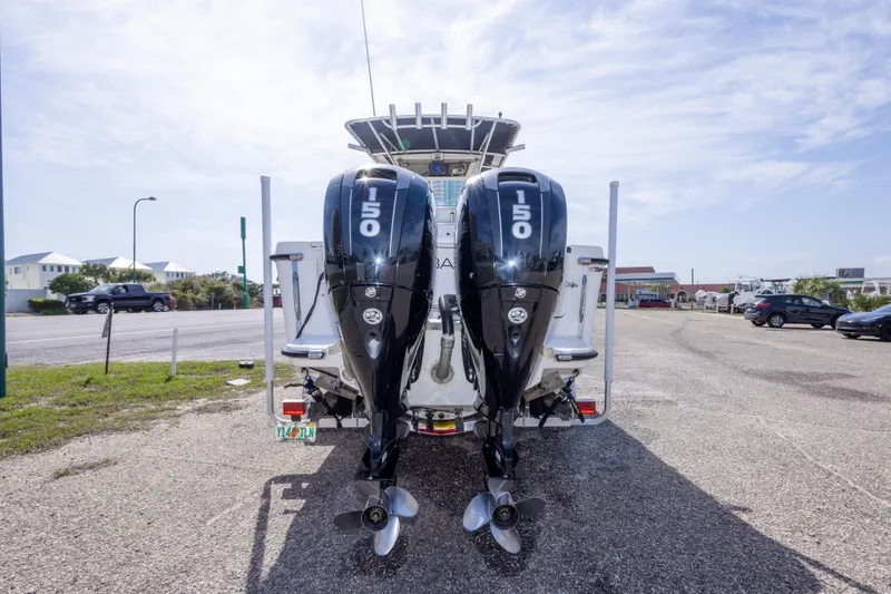Slide: The Image of 1997 Robalo R230 Center Console boat with dual 150 horsepower engines, parked outdoors. - 17