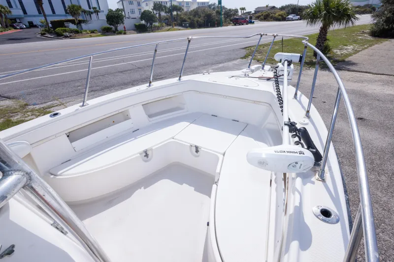 Slide: The Image of 1997 Robalo R230 Center Console boat with spacious deck and seating, parked near a road. - 19
