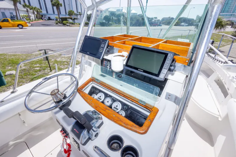 Slide: The Image of 1997 Robalo R230 Center Console boat dashboard with steering wheel and navigation screens. - 20