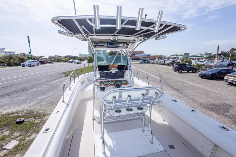 Slide: The Image of 1997 Robalo R230 Center Console boat with T-top, parked near a road. - 23