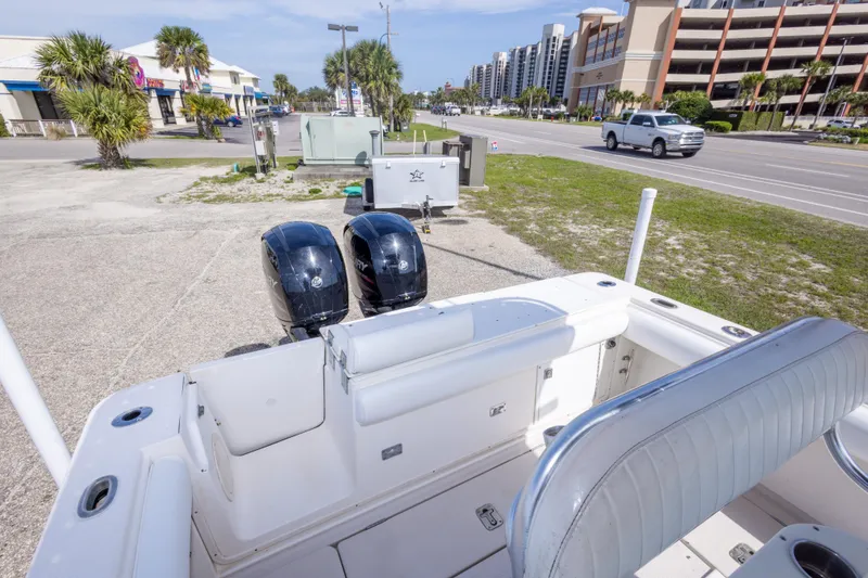 Slide: The Image of 1997 Robalo R230 Center Console boat with dual Mercury engines, parked near a road. - 32