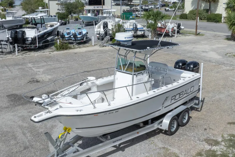 Slide: The Image of 1997 Robalo R230 Center Console boat on trailer, parked in a marina lot. - 7