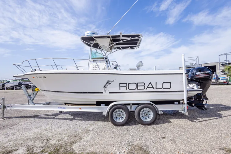 Slide: The Image of 1997 Robalo R230 Center Console boat on trailer, side view under clear sky. - 8