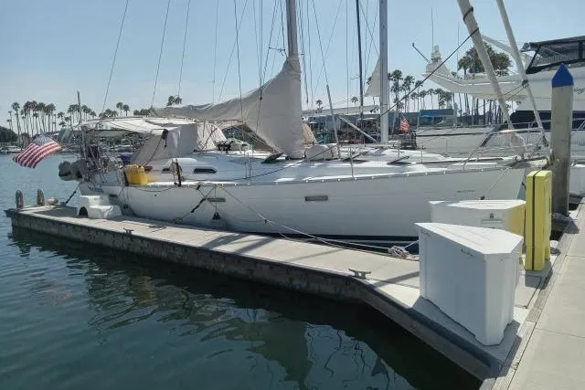 The Image of 2005 Beneteau 393 sailboat docked at marina with American flag. - 1