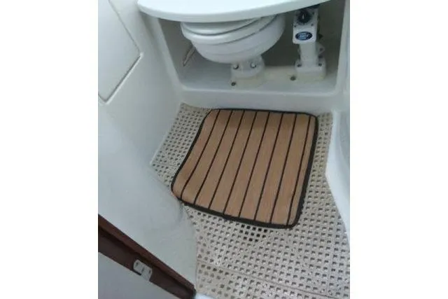 Slide: The Image of 2005 Beneteau 393 yacht bathroom with toilet and striped mat. - 17