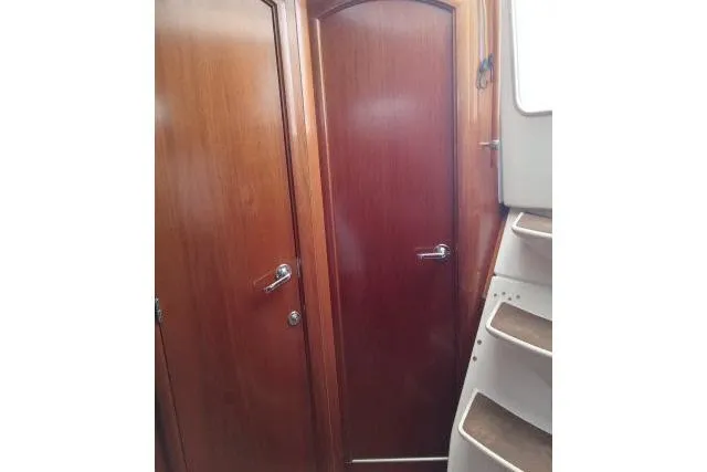 Slide: The Image of Interior view of 2005 Beneteau 393 yacht, featuring wooden doors and staircase. - 19